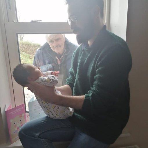 Η φωτογραφία που έγινε viral | Ένας παππούς αντικρίζει για πρώτη φορά τον νεογέννητο εγγονό του την εποχή του κορωνοϊού