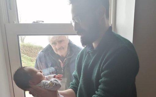 Η φωτογραφία που έγινε viral | Ένας παππούς αντικρίζει για πρώτη φορά τον νεογέννητο εγγονό του την εποχή του κορωνοϊού